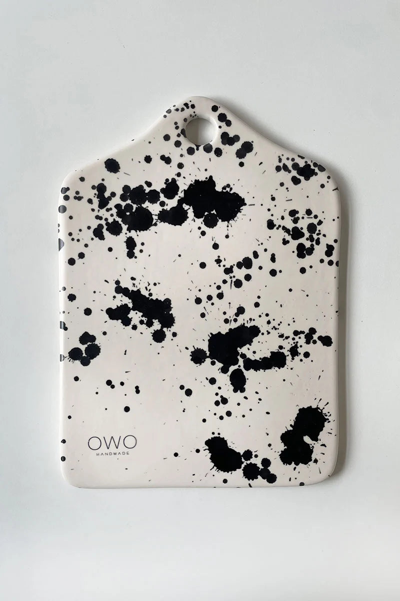 Handcrafted ceramic cheese board with hand-painted black splatters