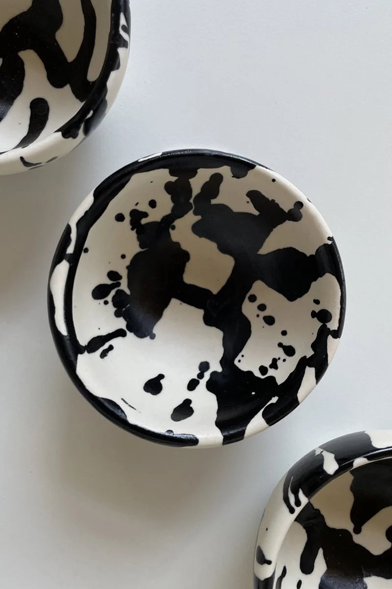 Small ceramic dipping bowls featuring hand-pained black splatters by OWO Ceramics