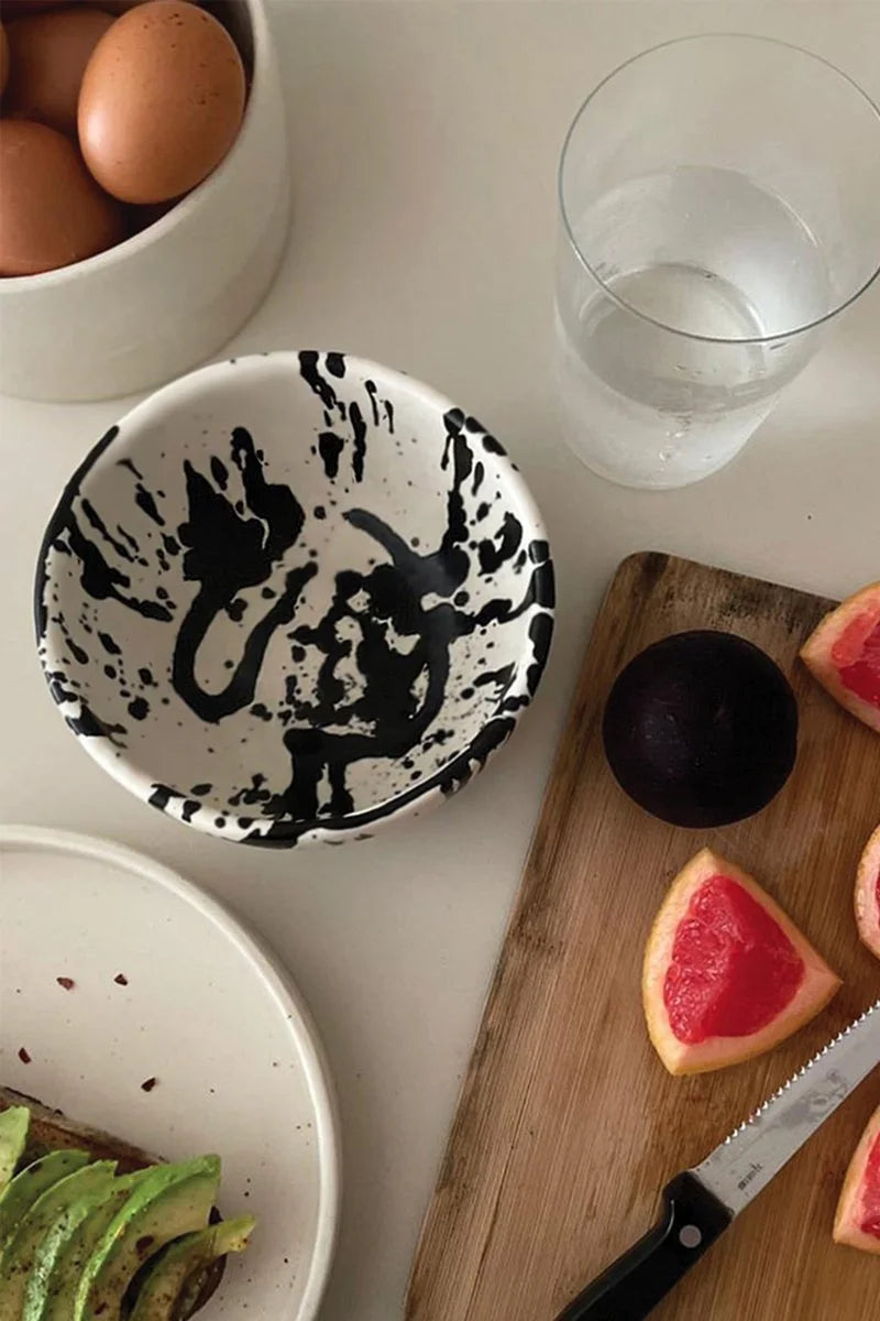 Kitchen counter scene showcasing a cutting board, fresh fruits, and a handmade pottery bowl with splatters