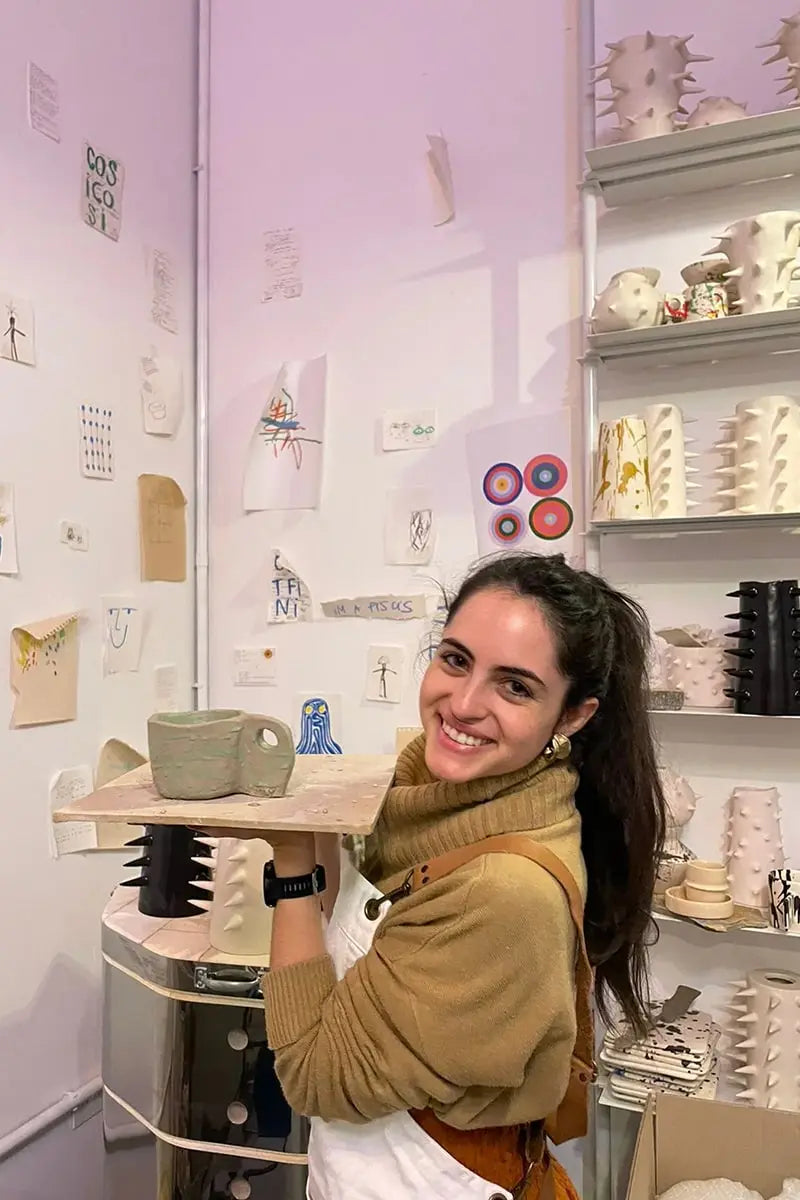 Student posing with the pottery mug she hand-built at OWO’s ceramic class in Buenos Aires